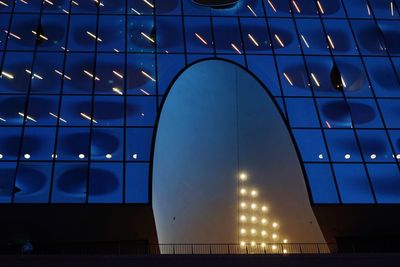 Low angle view of illuminated building against blue sky