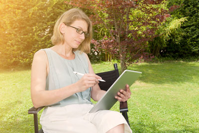 Young woman using mobile phone in park