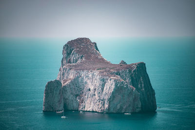 Panoramic view of rock formation in sea against sky