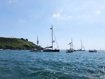 Sailboats sailing in sea against sky
