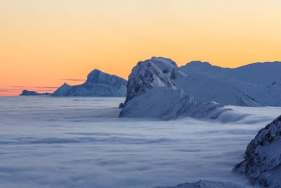 Scenic view of snowcapped mountains against sky during sunset