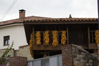 Low angle view of house roof and building against sky