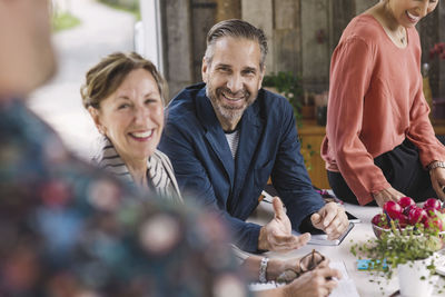 Happy business people looking at colleague during meeting in portable office truck