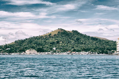 Scenic view of sea by buildings against sky