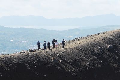 Group of people on rock against sky