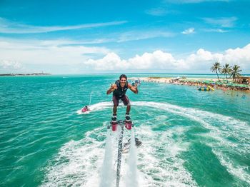 Man surfing in sea against sky