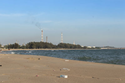 View of factory at beach against sky