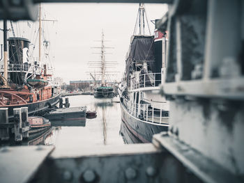 Sailboats moored at harbor