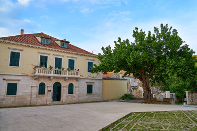 Houses by street in town against sky