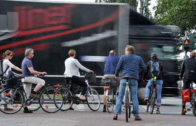 Rear view of people walking on street in city