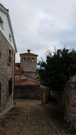 Old building by trees against sky