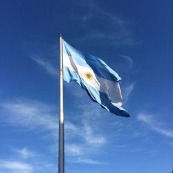 Low angle view of argentinian flag against blue sky