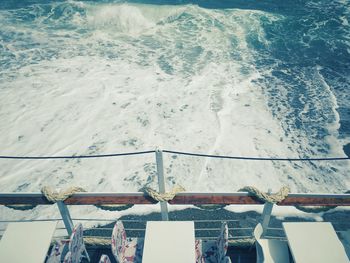 High angle view of deck chairs by sea