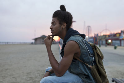 Young man thoughtful gazing out to sea