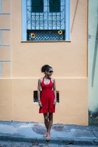 Portrait of a woman wearing red clothes on the street in bright sunny day. salvador, bahia, brazil.