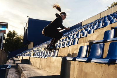 Full length of woman exercising in stadium