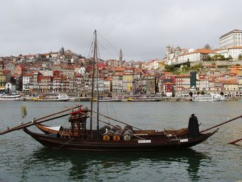 Boat in river with city in background