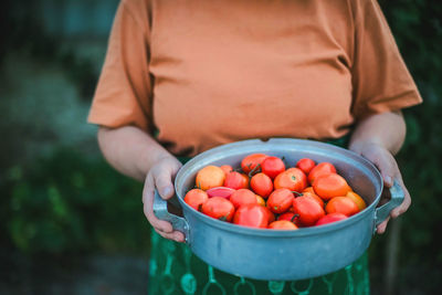 Midsection of man holding strawberries in basket