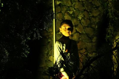 Boy on tree trunk at night