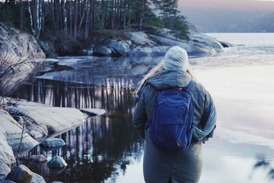 Rear view of woman standing in lake during winter