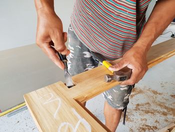 Midsection of carpenter working in workshop