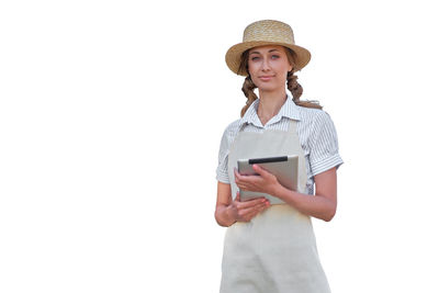 Portrait of young woman holding mobile phone against white background