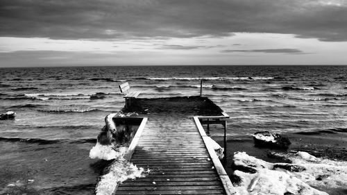 Pier on beach against sky