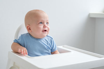 Portrait of cute baby boy sitting on table