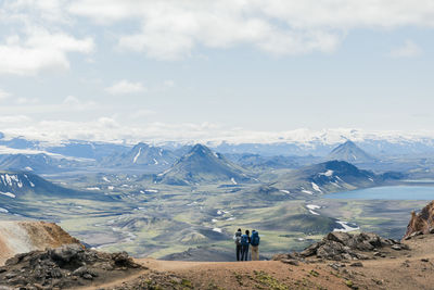 Back of three hikers admiring view of amazing landscape in iceland while trekking laugavegur trail