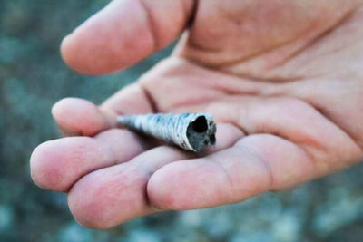 Close-up of hand holding cigarette