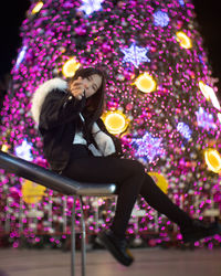 Woman sitting with illuminated lights