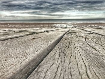 Surface level of sandy beach against clouds