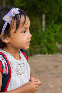 A girl carrying a bag with a label that says  naruedi kittiwaraporn  is ready to go to school.