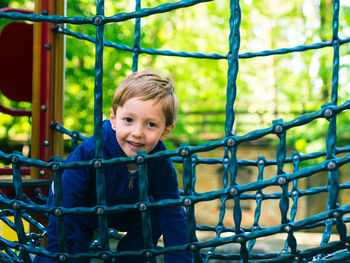 Smiling boy standing in jungle gym
