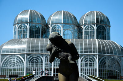 Low angle view of statue in city against clear sky