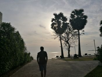 Rear view of silhouette man on road against sky