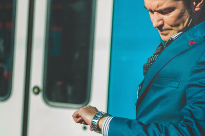 Midsection of man looking through train window