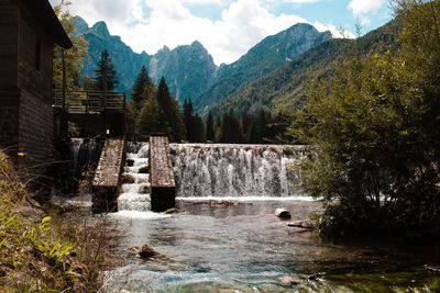 Scenic view of waterfall against sky in mountain 