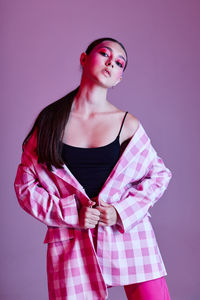 Young woman standing against gray background