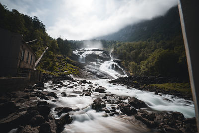 Scenic view of waterfall against sky