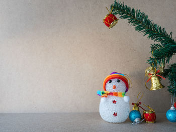 Christmas decorations on tree against wall