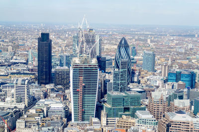 Aerial view of buildings in city against sky