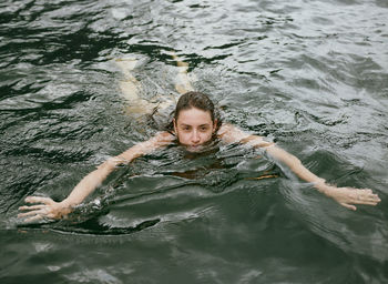 High angle portrait of young woman swimming in pool