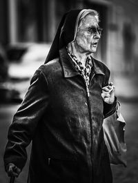 Side view of senior woman wearing sunglasses while standing on street