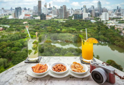 High angle view of drink on table against buildings in city