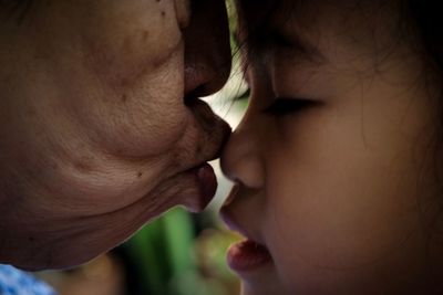 Close-up of grandmother kissing granddaughter outdoors