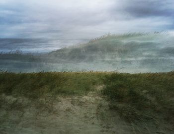 Scenic view of sea against cloudy sky