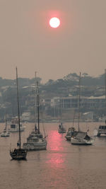 Australia bush fire ,red sky full of smoke,sun reflection on water