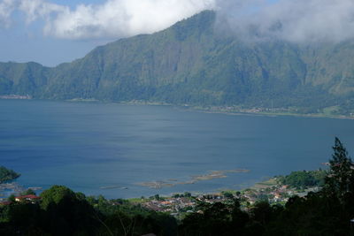 Scenic view of sea and mountains against sky