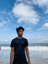 Man standing at beach against sky